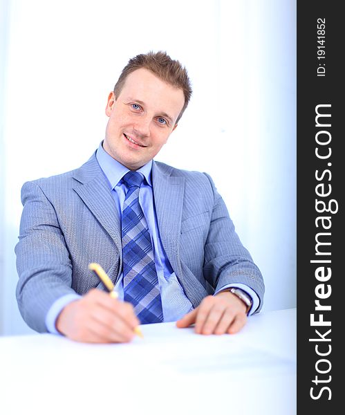 Full length of a handsome business man with hands folded against white background