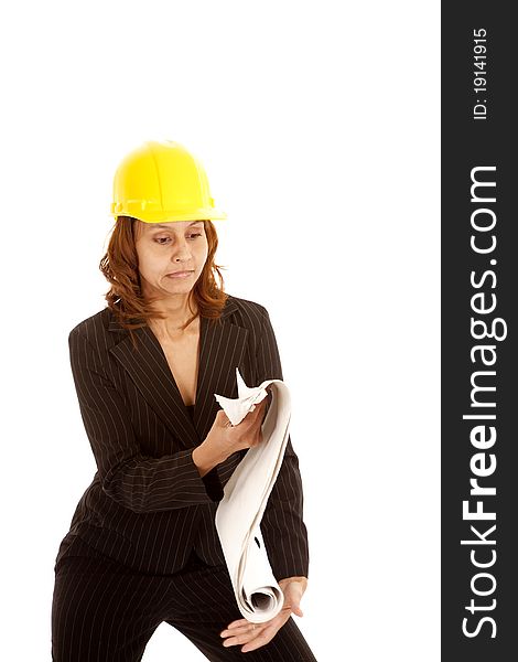 A woman is in a yellow hard hat about to drop some plans. A woman is in a yellow hard hat about to drop some plans.