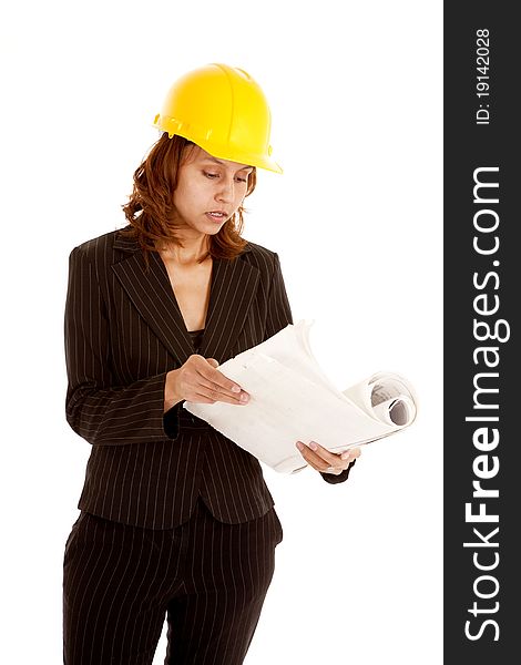 A woman is in a business suit and a hard hat looking at plans. A woman is in a business suit and a hard hat looking at plans.