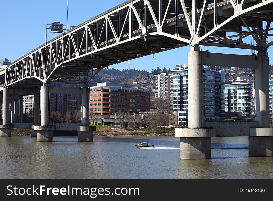 A speedboat passing through the massive pillars of the I-5 overpass, Portland Oregon. A speedboat passing through the massive pillars of the I-5 overpass, Portland Oregon.