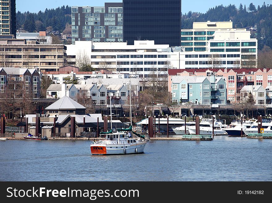 A large sailboat cruising close to the marina park in Portland OR. A large sailboat cruising close to the marina park in Portland OR.