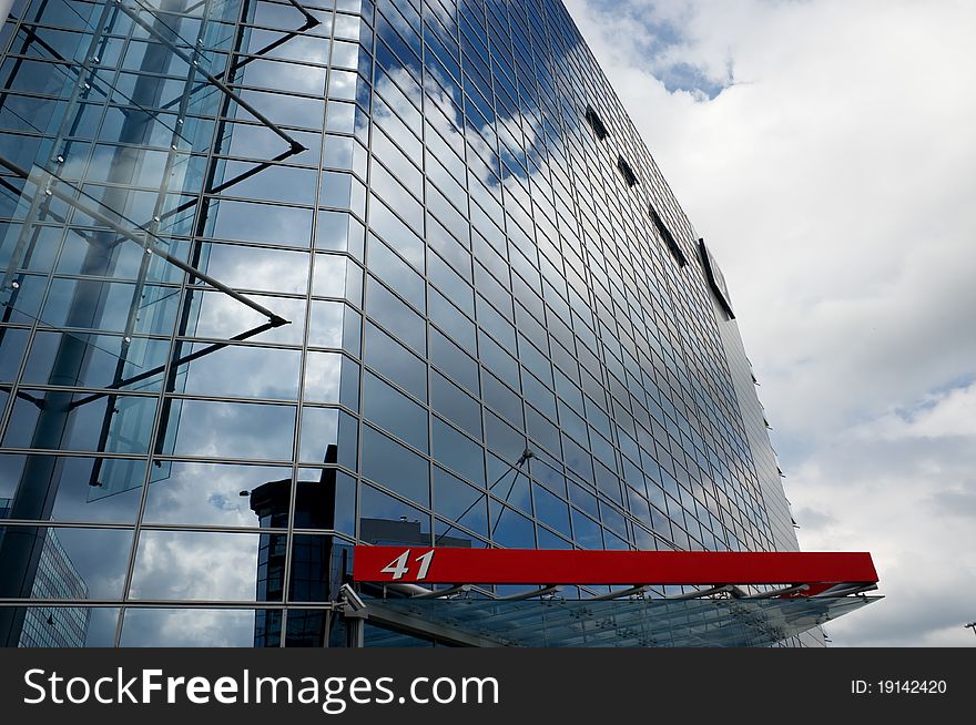 Modern corporate glass building with reflections, blue sky, and clouds. Modern corporate glass building with reflections, blue sky, and clouds