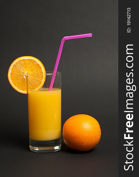 Fresh orange juice in a glass with drinking straw