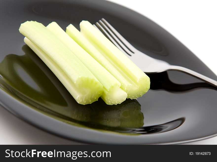 Green celery on black plate. Green celery on black plate