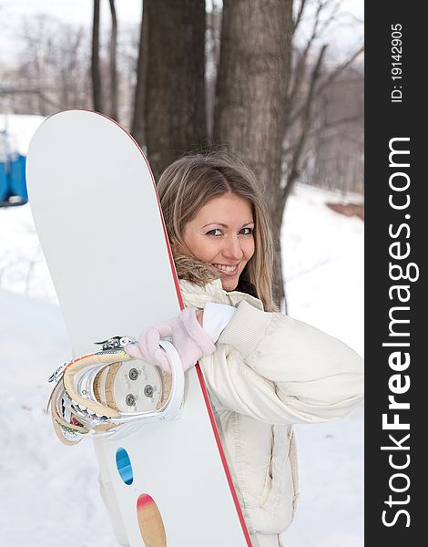Young woman with snowboard at winter resort. Young woman with snowboard at winter resort