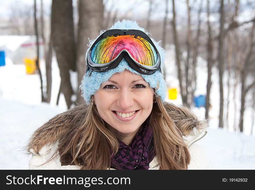 Young smiling woman in ski goggles at winter resort. Young smiling woman in ski goggles at winter resort