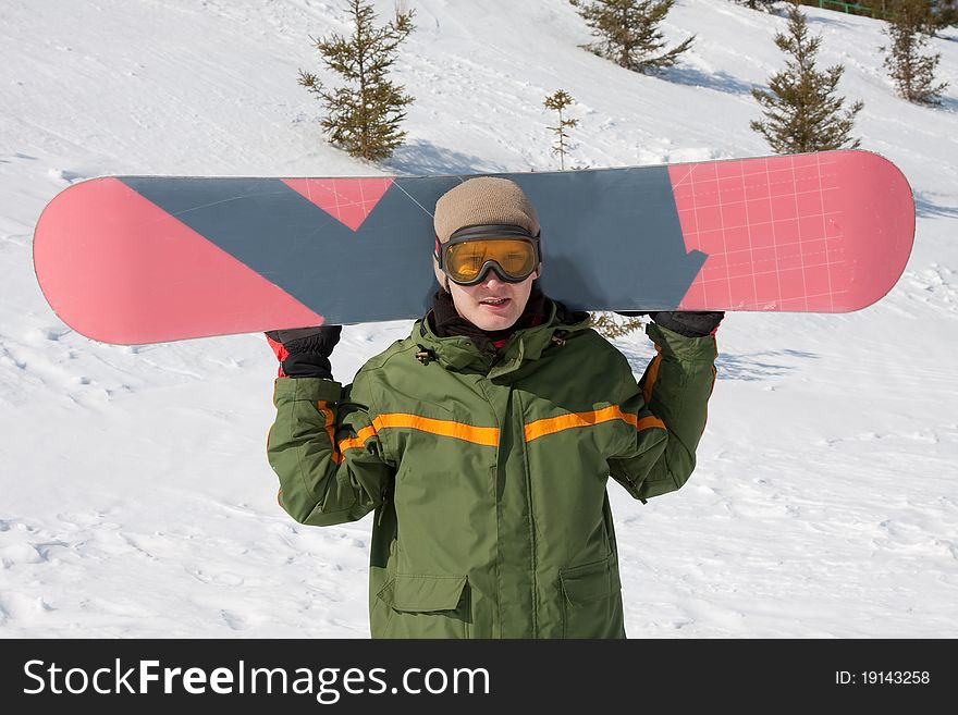 Young man with snowboard at winter resort