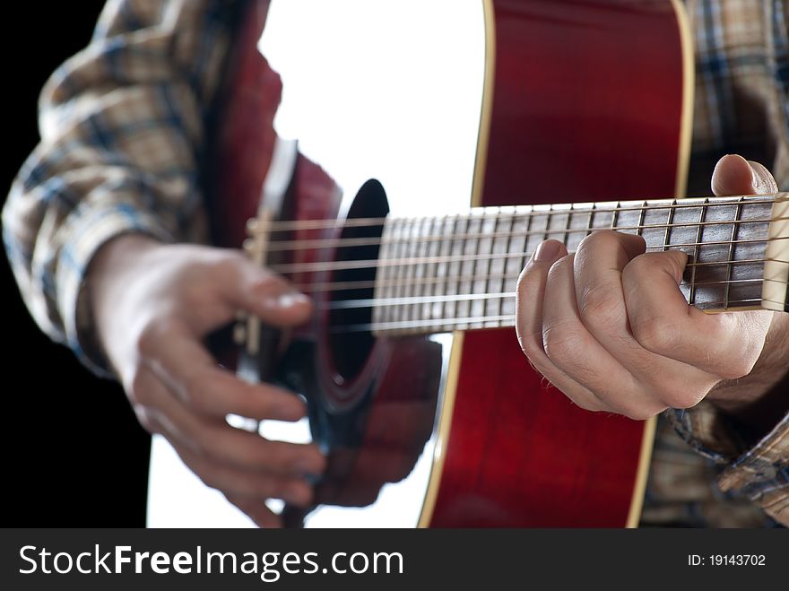 Closeup. Man playing guitar on black background.