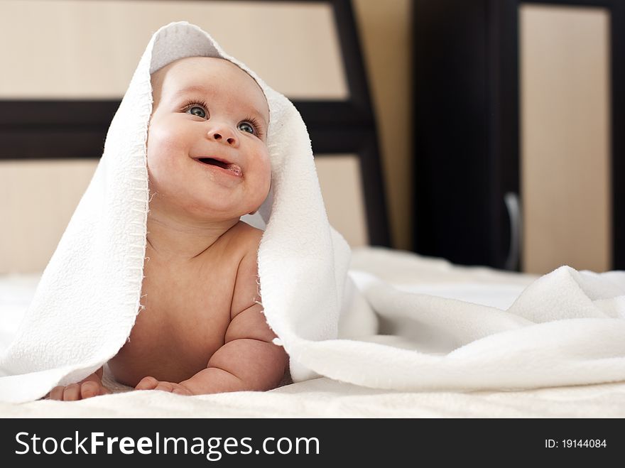 Happy smiling baby girl on bed after bath. Happy smiling baby girl on bed after bath.