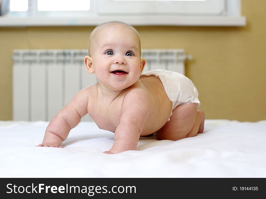 Small Smiling Baby On Bed.