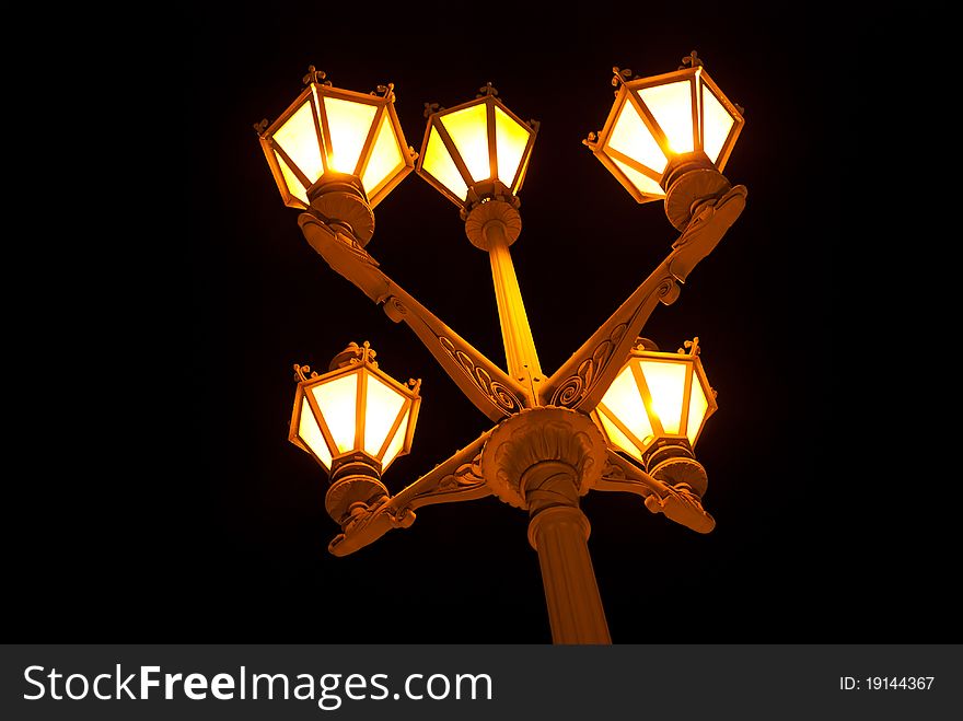 Old-fashioned lantern with five lamps at night