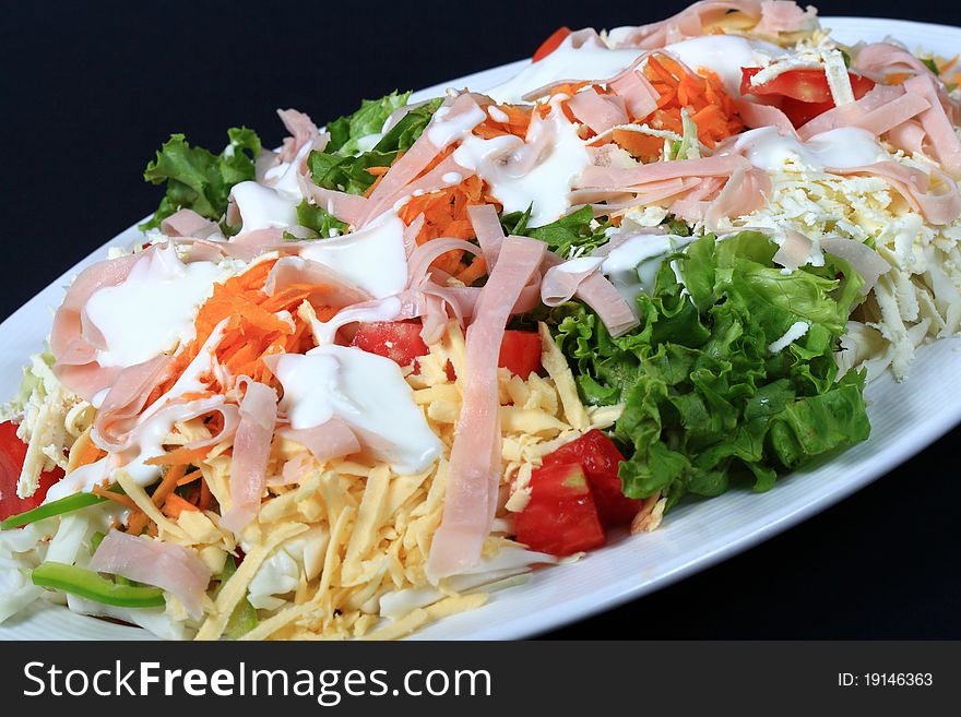 Fresh salad from vegetables, ham and cheese