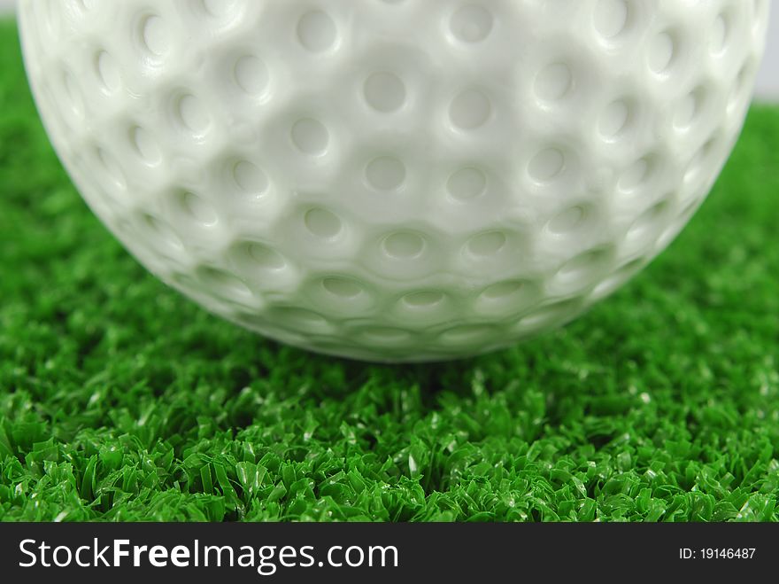 Closeup of the golf ball on the green grass turf