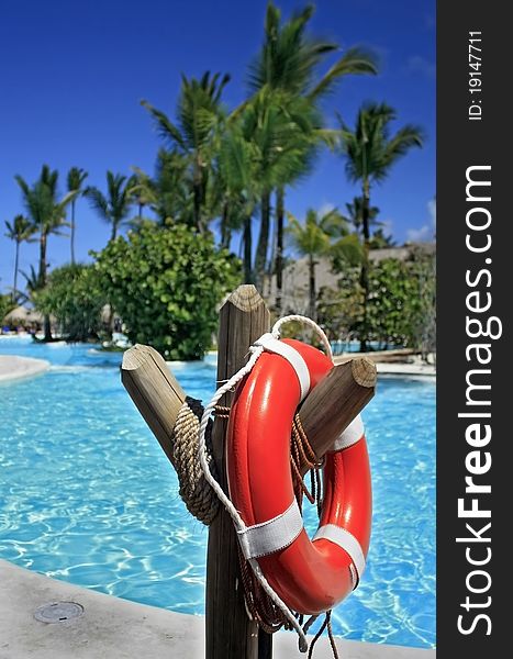 Red lifebuoy at the resort swimming pool. Red lifebuoy at the resort swimming pool