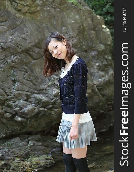 Young japanese woman standing on the rock