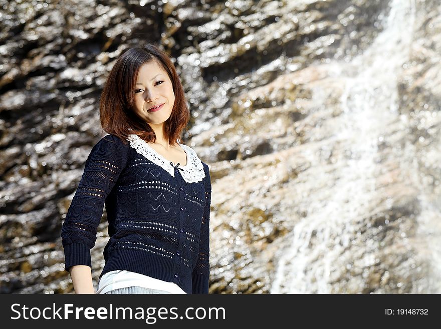 Young japanese woman near the waterfall