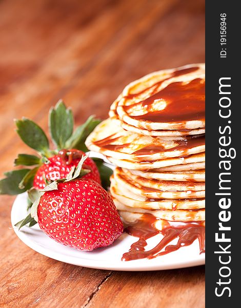 Pancakes stak topped with chocolate souce on wooden table, vertical picture. Pancakes stak topped with chocolate souce on wooden table, vertical picture.