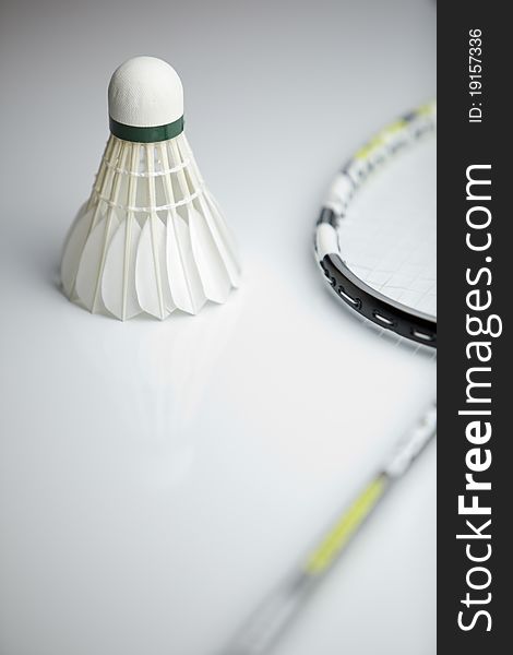 Badminton shuttlecock and racket on white background (shallow DOF; color toned image)