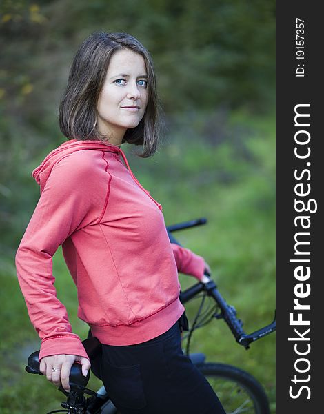 Pretty young female biker outddors on her mountain bike (shallow DOF; selective focus)