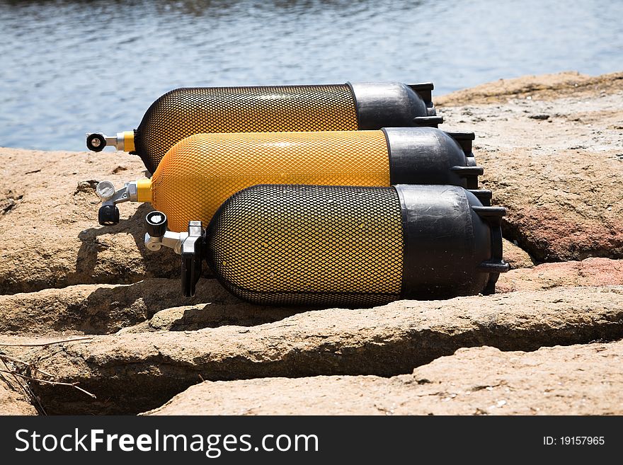 Yellow diver tanks with net, rocks and water. Yellow diver tanks with net, rocks and water