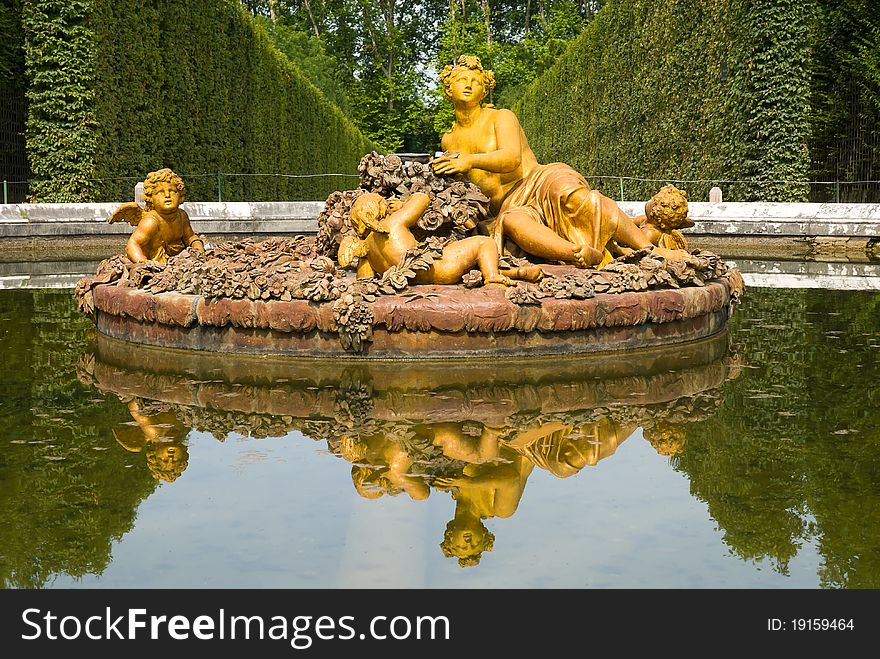 Golden statue of flora fountain in Versailles Palace garden, city Paris, France.