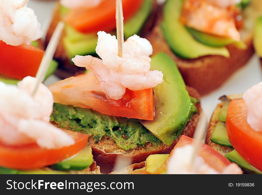 Sandwiches garnish with shrimps, avokado and lettuce close up, snack. Sandwiches garnish with shrimps, avokado and lettuce close up, snack