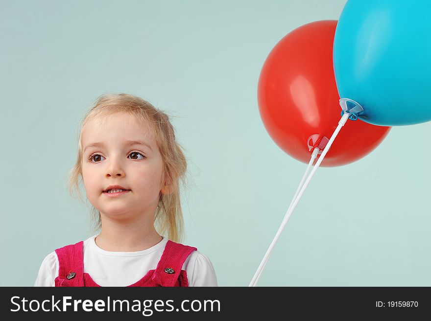 Lovely blond little girl with balloons. Portrait