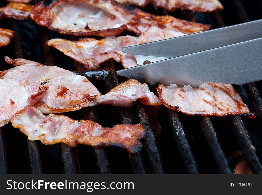 Rashers of bacon on a barbeque grill. Rashers of bacon on a barbeque grill