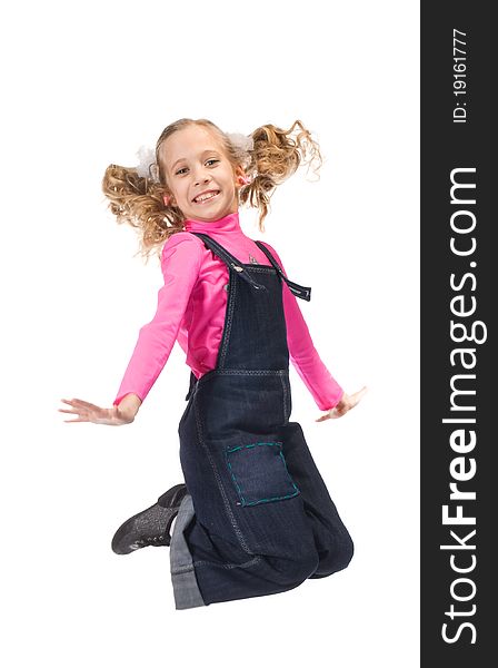 Jumping happy young girl in pink t-shirt and blue overalls