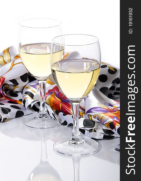 Two glasses of white wine and a scarf on a white background. Two glasses of white wine and a scarf on a white background