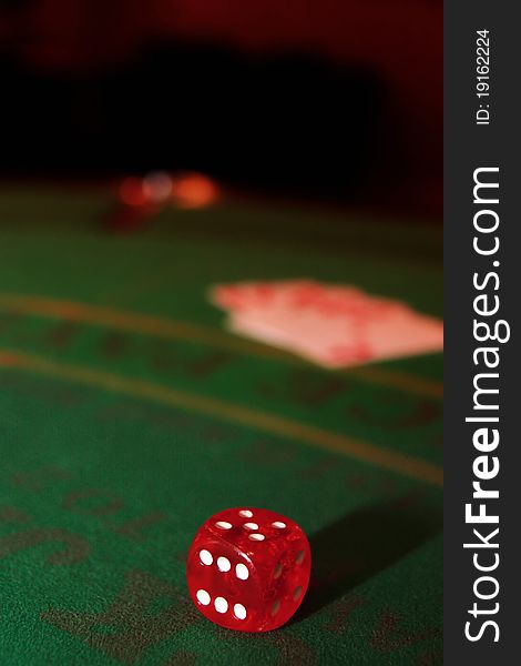 Green casino table with dice and a blurred hand of a royal flush in a poker game. Green casino table with dice and a blurred hand of a royal flush in a poker game