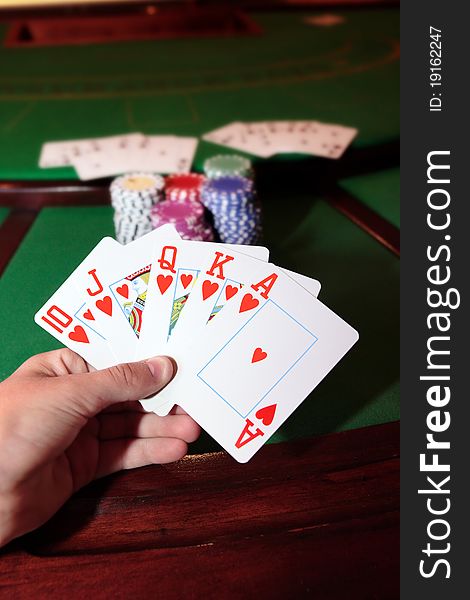 Green casino table with a hand of a royal flush in a poker game. Green casino table with a hand of a royal flush in a poker game