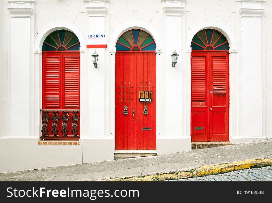 Entrance of a classic styled apartment with vintage tall red windows and marks FOR RENT. Entrance of a classic styled apartment with vintage tall red windows and marks FOR RENT