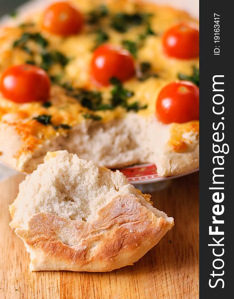A pice of a tasty italian cake with cherry tomatoes, cheese and herbs. A pice of a tasty italian cake with cherry tomatoes, cheese and herbs