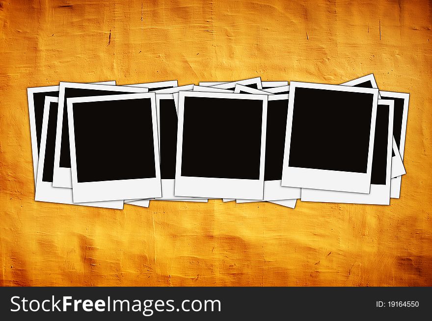 Stack of instant photos on vintage yellow wall with artistic shadows added