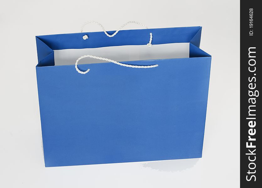 Blue package for purchases in shop on a gray background. Blue package for purchases in shop on a gray background