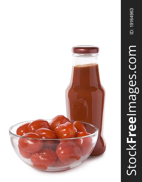 Red cherry tomatoes in a glass bowl with a bottle of ketchup isolated on white. Red cherry tomatoes in a glass bowl with a bottle of ketchup isolated on white