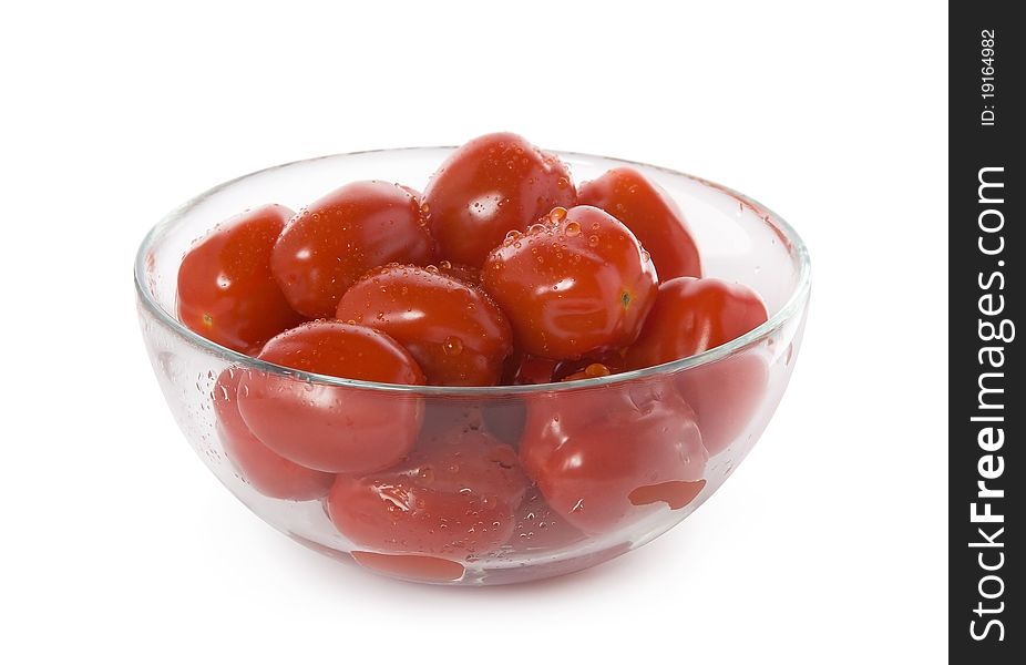 Red cherry tomatoes in a glass bowl isolated on white