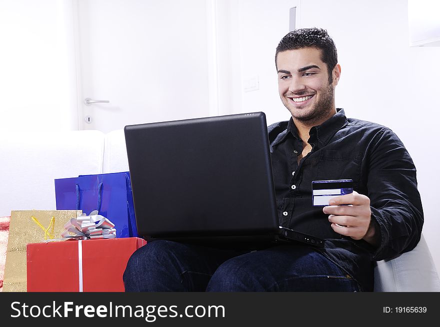 Young man buying on internet with laptop in indoor. Young man buying on internet with laptop in indoor