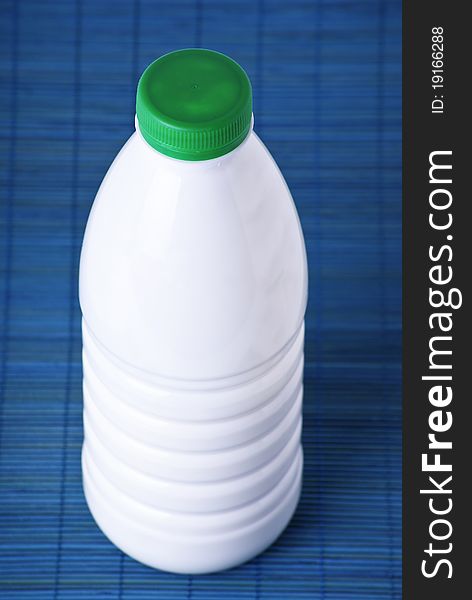 Plastic bottle of milk isolated on blue background