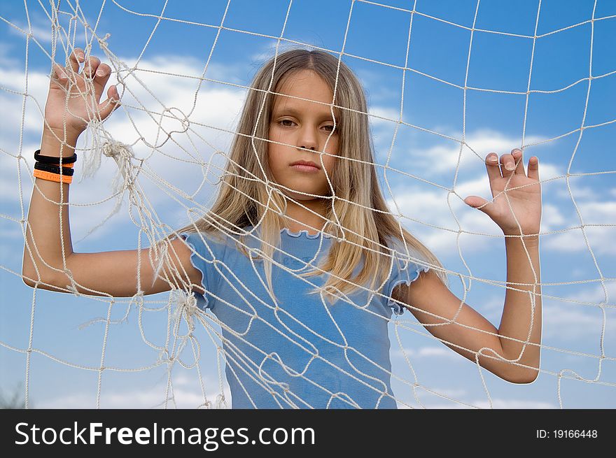 The girl looks through a rope net. The girl looks through a rope net