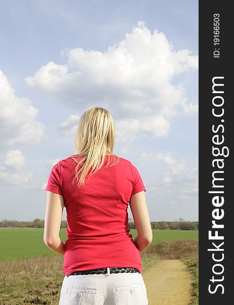 Lonely young woman on a dirt road