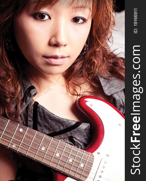 Young asian woman with a red guitar. Young asian woman with a red guitar.