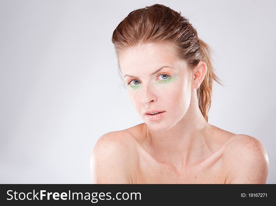 Beautiful young red-haired woman looking at camera