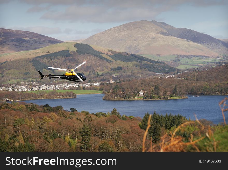 Helicopter flying above lake and trees. Helicopter flying above lake and trees