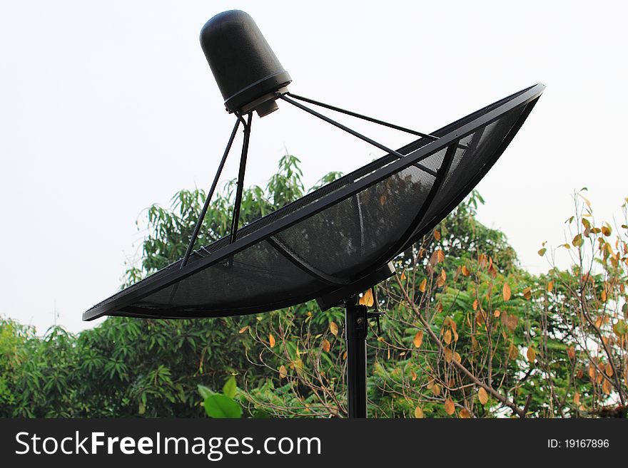 Big black satellite dish on roof. Big black satellite dish on roof.