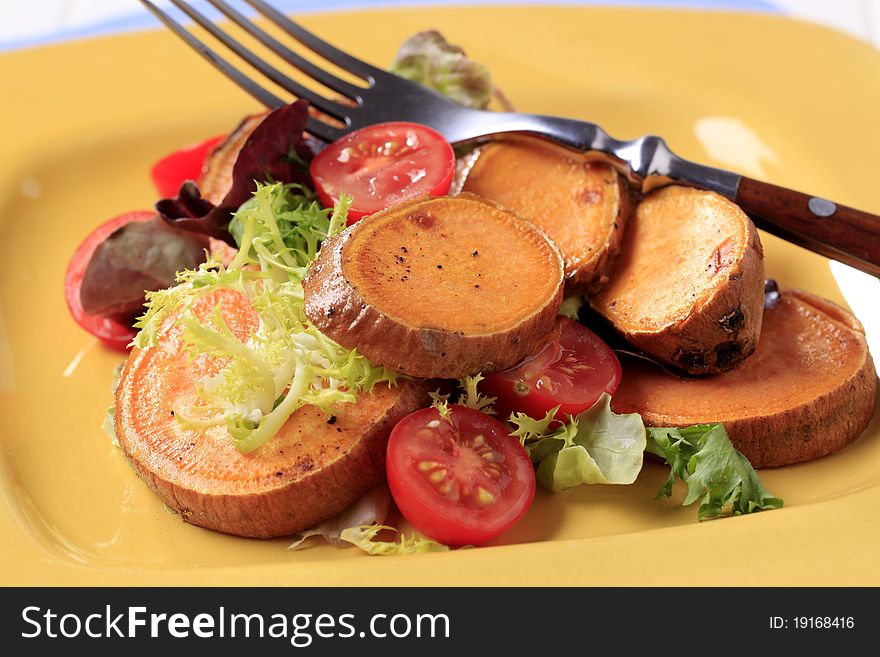 Pan-roasted potatoes with salad greens and tomatoes. Pan-roasted potatoes with salad greens and tomatoes