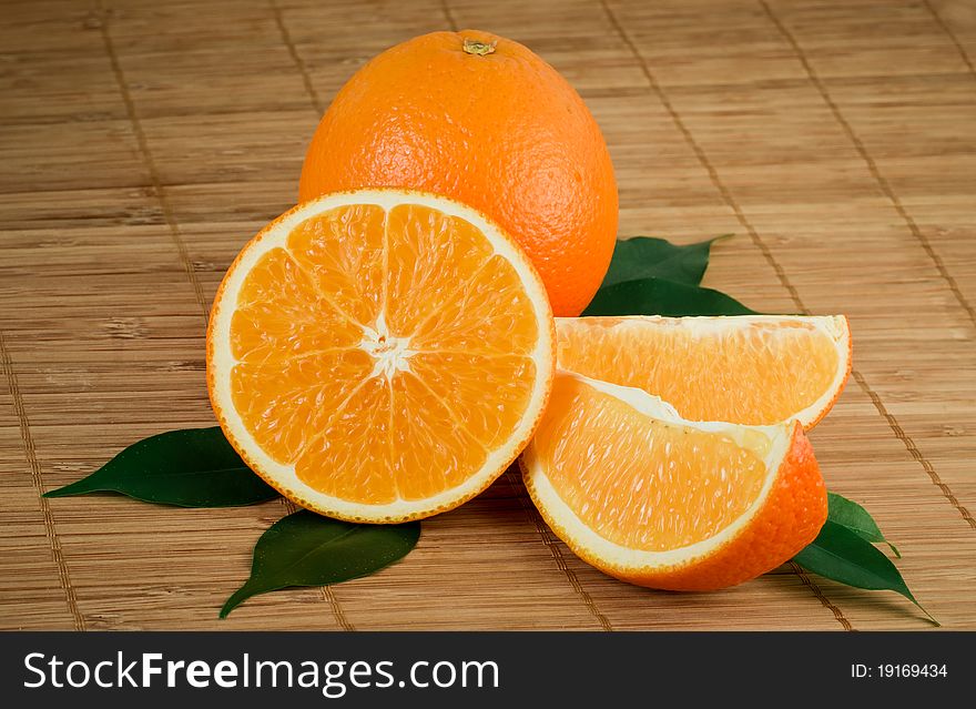 Fresh orange with segments and leaves on a mat. Fresh orange with segments and leaves on a mat