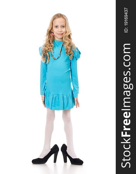Young girl in blue dress posing in mothers shoes. Young girl in blue dress posing in mothers shoes