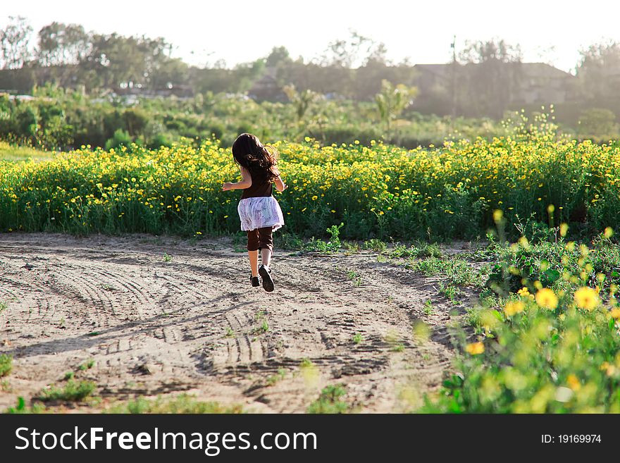 Little girl running towards flowers. Little girl running towards flowers.